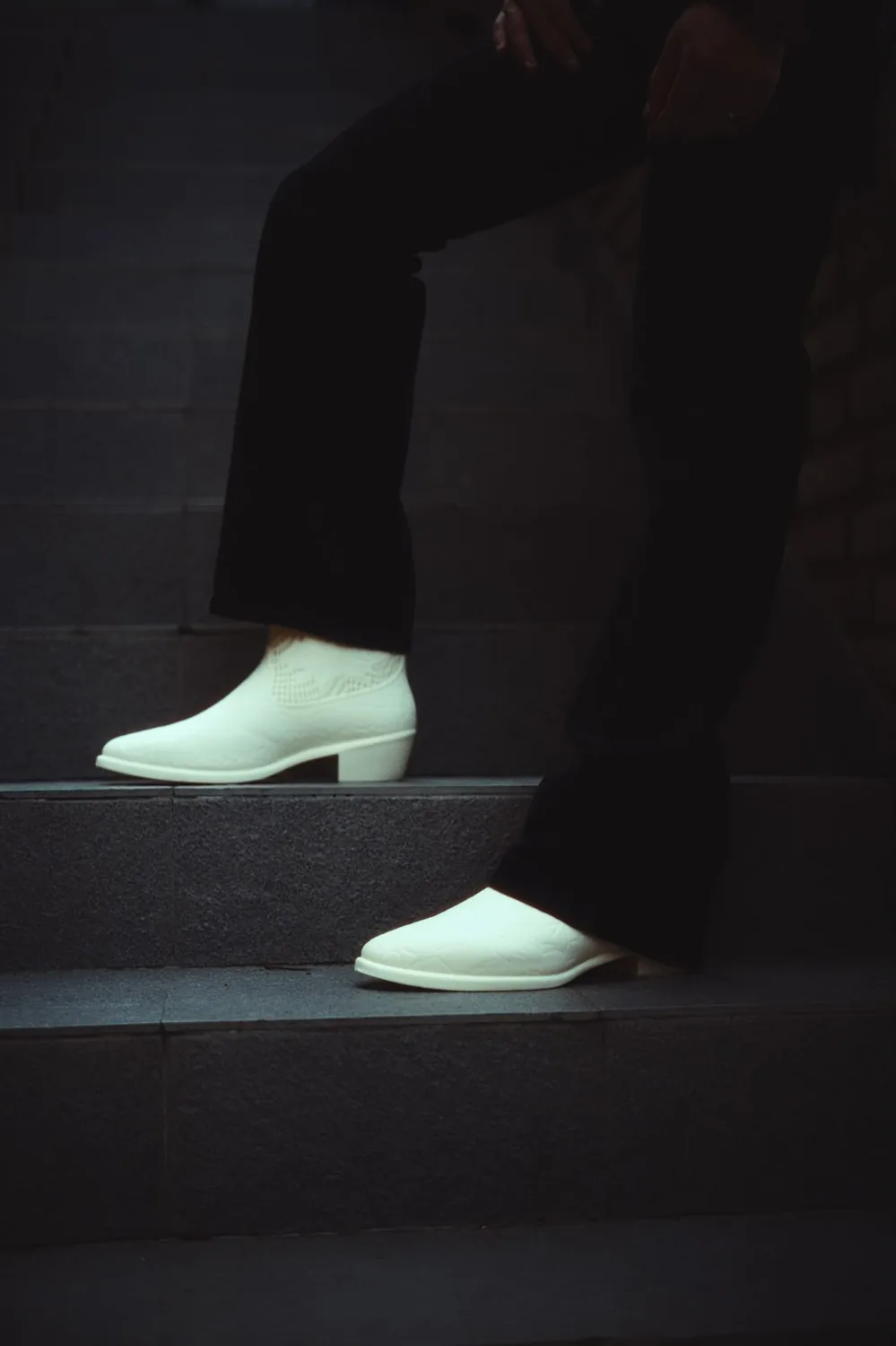 Pair of white printed cowboy boots on stairs